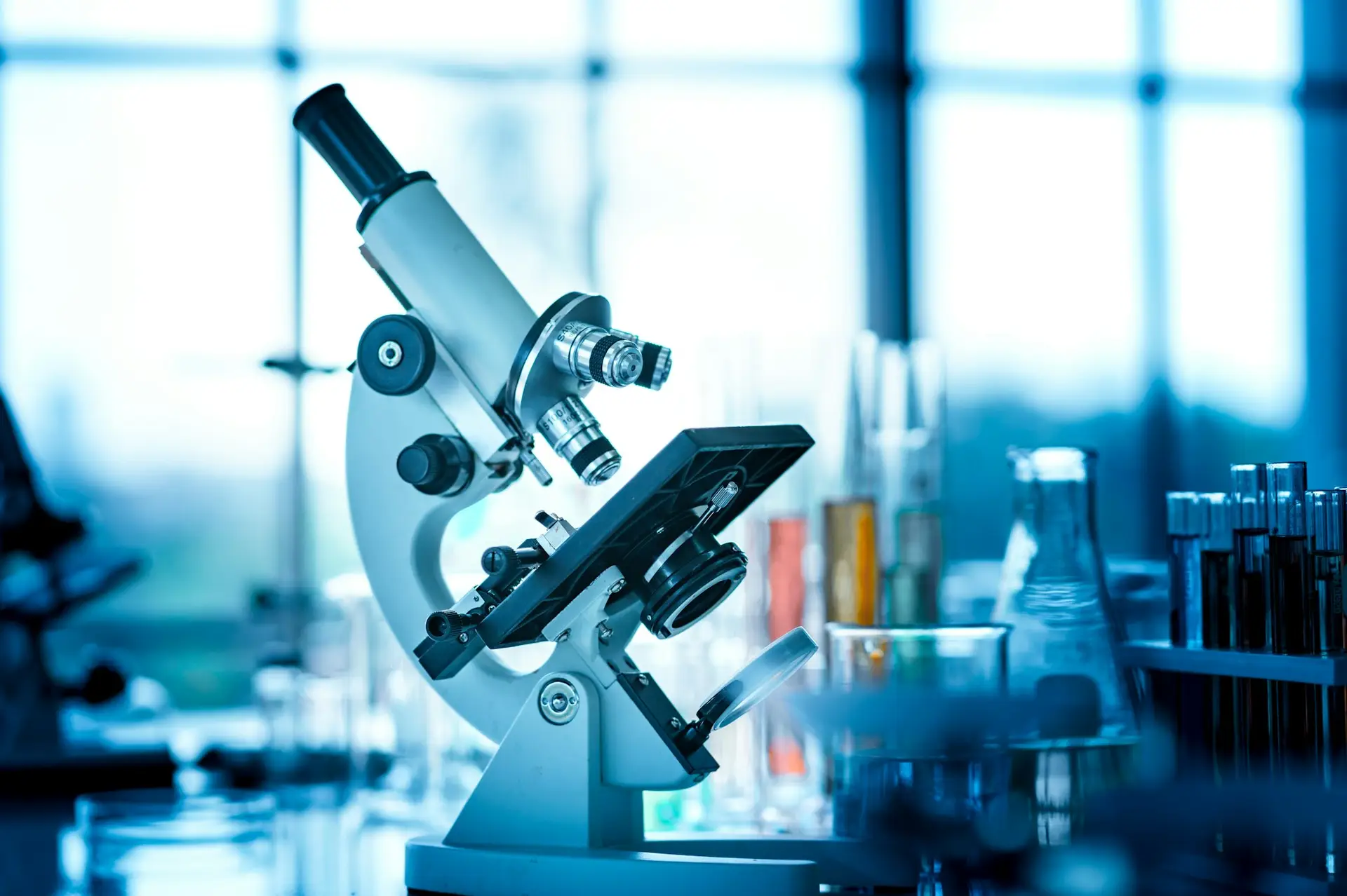 Microscope on the table with chemical tube and glassware in laboratory, Science research technology